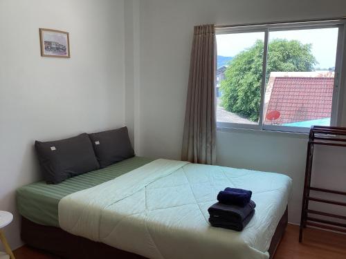 a small bedroom with a bed with a window at mom's home in Phuket