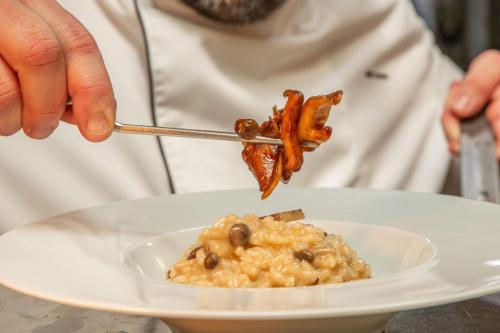 a person eating a plate of food with bacon and beans at VIP Executive Arts Hotel in Lisbon