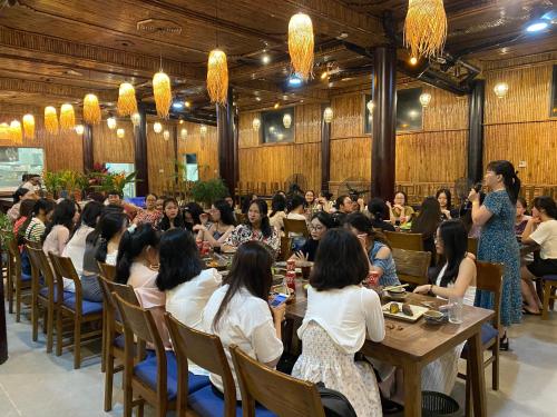 a group of people sitting at tables in a restaurant at Hồ Đá Cổ Thiên Long Resort Hòa Bình in Hòa Bình