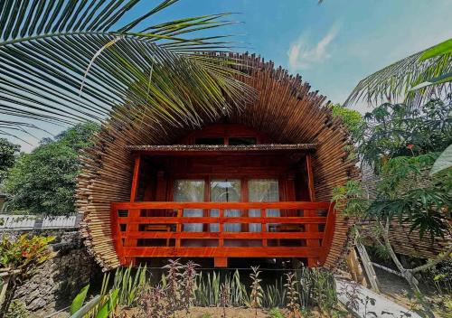 a brick building with a window and a palm tree at Lagoona Beach Bungalows - Eco Bungalows Batukaras in Batukaras