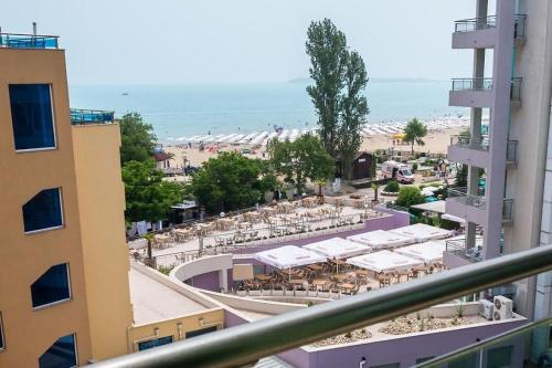 a view of a beach with tables and umbrellas at Family Hotel Gallery - Sunny Beach in Sunny Beach