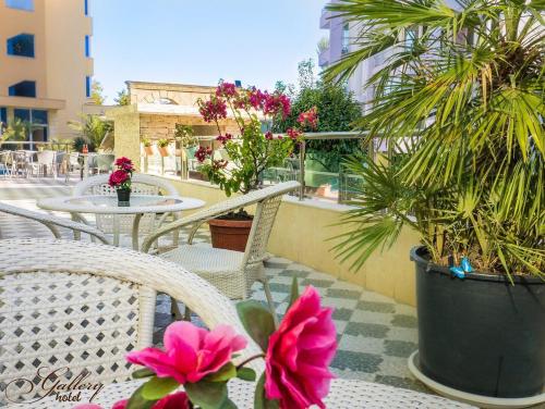 a patio with chairs and tables with flowers and plants at Family Hotel Gallery - Sunny Beach in Sunny Beach