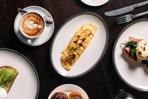 a table with plates of food and a cup of coffee at Crowne Plaza Canberra by IHG in Canberra