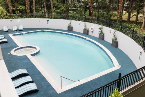 a large swimming pool with chairs around it at Crowne Plaza Canberra by IHG in Canberra