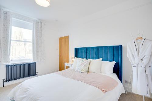 ein Schlafzimmer mit einem großen Bett mit blauem Kopfteil in der Unterkunft NEW The Procession Grade II Listed and Pet Friendly in Berwick-Upon-Tweed
