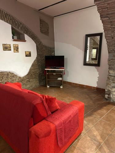 a living room with a red couch and a television at Estia Bed and Relax in Benevento