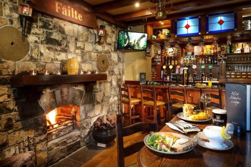 a restaurant with a fireplace and a table with food at 3 bedroom Townhouse in the heart of the Burren in Ballyvaughan