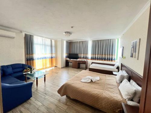 a hotel room with a bed and a blue couch at Family Hotel Gallery - Sunny Beach in Sunny Beach