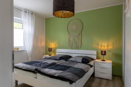 a bedroom with a large bed with green walls at Ferienwohnung Sonnenstrahl am Harkebrügger See mit Sauna in Barßel
