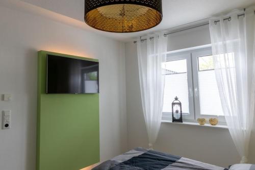 a bedroom with a green door and a window at Ferienwohnung Sonnenstrahl am Harkebrügger See mit Sauna in Barßel