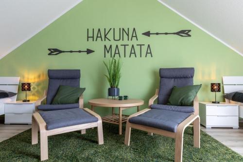 a bedroom with two chairs and a table with a sign that reads hakuma at Ferienwohnung Sonnenstrahl am Harkebrügger See mit Sauna in Barßel