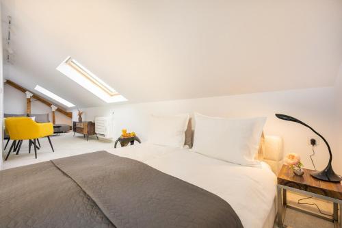 a bedroom with a large bed and a yellow chair at Apartment Musala N 05 in Varna City