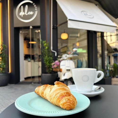a plate with a croissant and a cup of coffee at Apartment Musala N 05 in Varna City