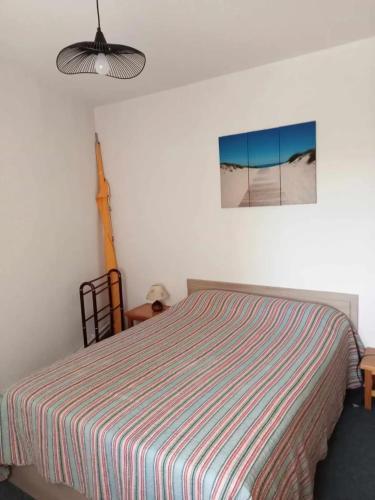 une chambre avec un lit avec une couverture rayée dans l'établissement Appartement confortable à Vaux-sur-Mer - 40 m² + terrasse, à Vaux-sur-Mer