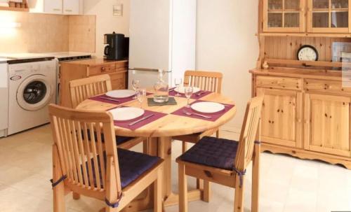 a kitchen with a wooden table with chairs and a dining room at Appartement confortable à Vaux-sur-Mer - 40 m² + terrasse in Vaux-sur-Mer