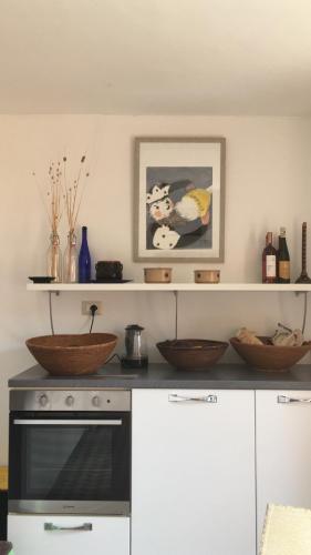 a kitchen with a stove and bowls on the counter at Maison de l artiste Zangs in Narbolia