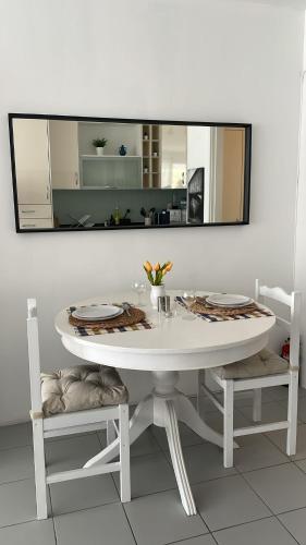 a white table with two chairs and a mirror at Casa Ligia in Vilamoura
