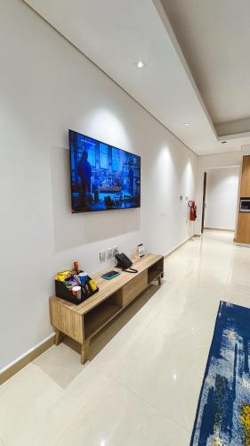 a living room with a large television on the wall at نخيل هجر للشقق الفندقية Nakheel Hajr Hotel Apartments in Al Hofuf