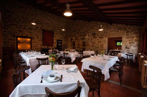 a dining room with tables and chairs with white table cloth at Rectoral de Castillon in Pantón