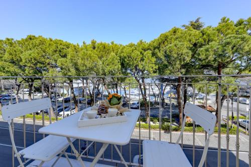 einen Tisch und Stühle auf einem Balkon mit Parkplatz in der Unterkunft Marriott Cocktail Lake Front Family apartment DesenzanoLoft Official Partner Homes & Villas by Marriott Bonvoy in Desenzano del Garda
