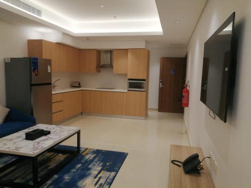 a living room with a table and a kitchen at نخيل هجر للشقق الفندقية Nakheel Hajr Hotel Apartments in Al Hofuf