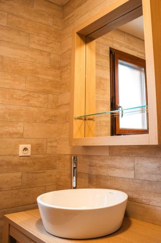 une salle de bain avec un lavabo blanc et un miroir dans l'établissement La Grange des Mios, à La Bresse