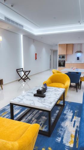 a living room with yellow chairs and a table at نخيل هجر للشقق الفندقية Nakheel Hajr Hotel Apartments in Al Hofuf