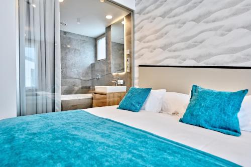 a bedroom with a large bed with blue pillows at Wellness Hotel Fénix in Liberec