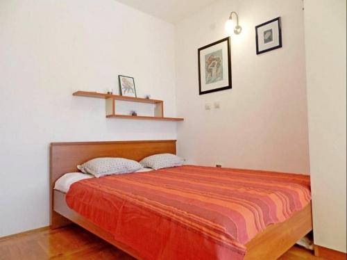 a bedroom with a bed with a orange blanket at Apartment Darko in Tribunj