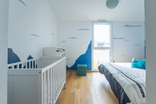 une chambre avec un lit et un mur bleu dans l'établissement Le Duplex des Catalans, à Marseille