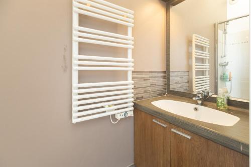 une salle de bain avec un lavabo et un miroir dans l'établissement Le Duplex des Catalans, à Marseille