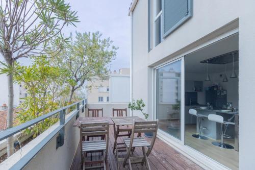 d'un balcon avec une table et des chaises en bois. dans l'établissement Le Duplex des Catalans, à Marseille