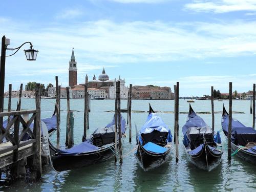 three gondolas are tied to a dock in the water at Villa Montello Pool, Jacuzzi, Ac, Wifi, Treviso in Volpago del Montello