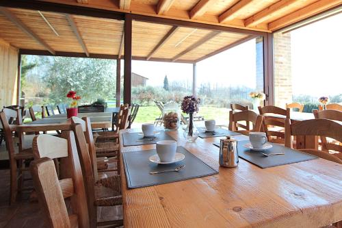 a wooden table with cups and saucers on it at Villa Montello Pool, Jacuzzi, Ac, Wifi, Treviso in Volpago del Montello