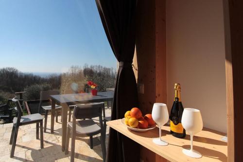 a table with a bowl of fruit and a bottle of wine at Villa Montello Pool, Jacuzzi, Ac, Wifi, Treviso in Volpago del Montello