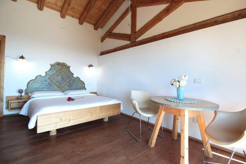 a bedroom with a bed and a table with chairs at Villa Montello Pool, Jacuzzi, Ac, Wifi, Treviso in Volpago del Montello