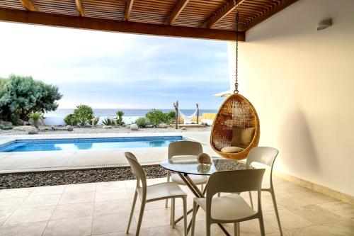 a dining room with a table and chairs and a pool at Casa Wayta in Los Órganos