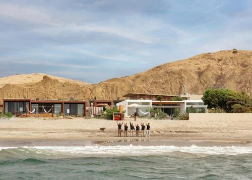 a group of people standing on the beach at Casa Wayta in Los Órganos