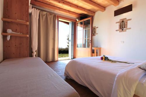 a bedroom with two beds and a large window at Villa Montello Pool, Jacuzzi, Ac, Wifi, Treviso in Volpago del Montello