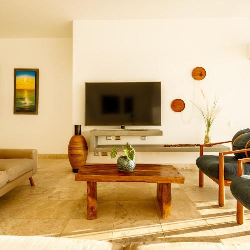 a living room with a coffee table and a tv at Casa Wayta in Los Órganos