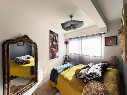 une chambre avec un miroir et un lit dans l'établissement Appartement de charme, Bénodet, à Bénodet