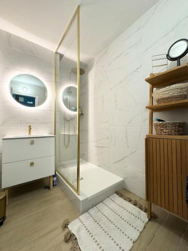 une salle de bain avec une douche, un lavabo et un miroir dans l'établissement Appartement de charme, Bénodet, à Bénodet