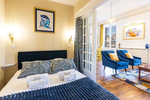 une chambre avec un lit et une chaise bleue dans l'établissement La Suite Matisse 700m centre-ville, à Angers