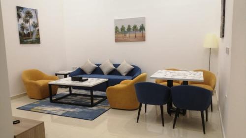 a living room with a couch and tables and chairs at نخيل هجر للشقق الفندقية Nakheel Hajr Hotel Apartments in Al Hofuf