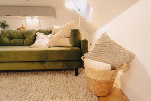 a living room with a green couch and a basket at Elegant Hideaway City Centre,1 Bed Flat, 3rd Floor in Bath