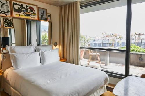 a bedroom with a large bed and a large window at Villa M in Paris