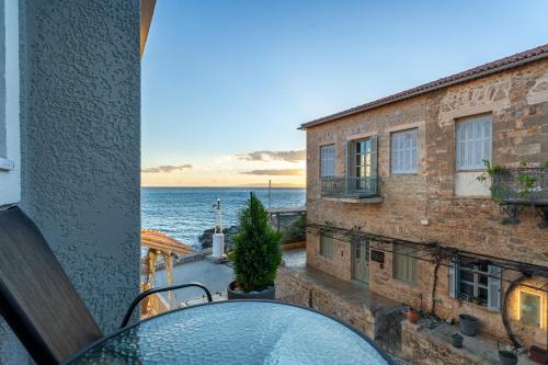 a table with a view of the ocean from a balcony at Marina Apartments in Kardamili