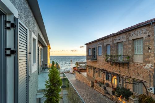 a view of the ocean from between two buildings at Marina Apartments in Kardamili