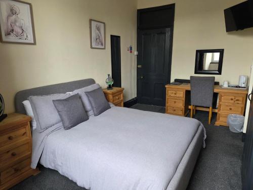 a bedroom with a large bed and a desk and a desk at St aubyn arms Hotel in Praze an Beeble