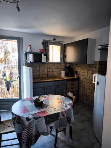 a kitchen with a table and a kitchen with a refrigerator at Studio Bas Verdon in Allemagne-en-Provence
